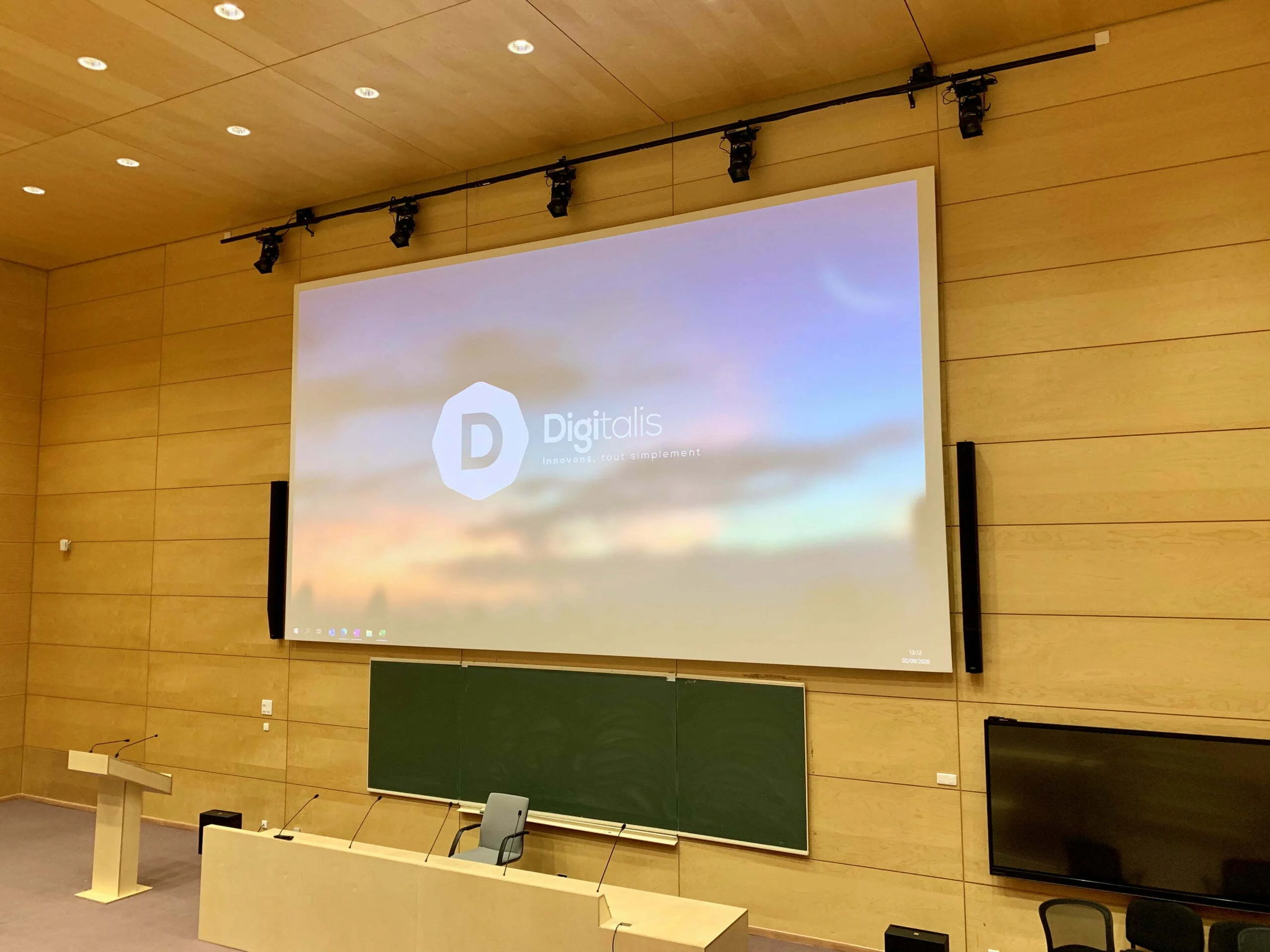 Salle de conférence avec écran de projection.