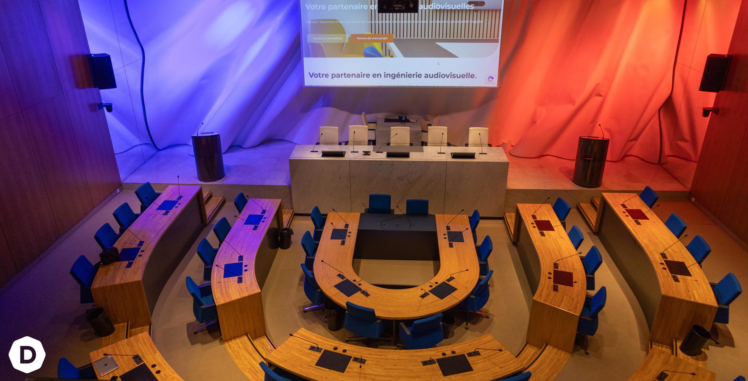 Salle de réunion avec sièges et podium.