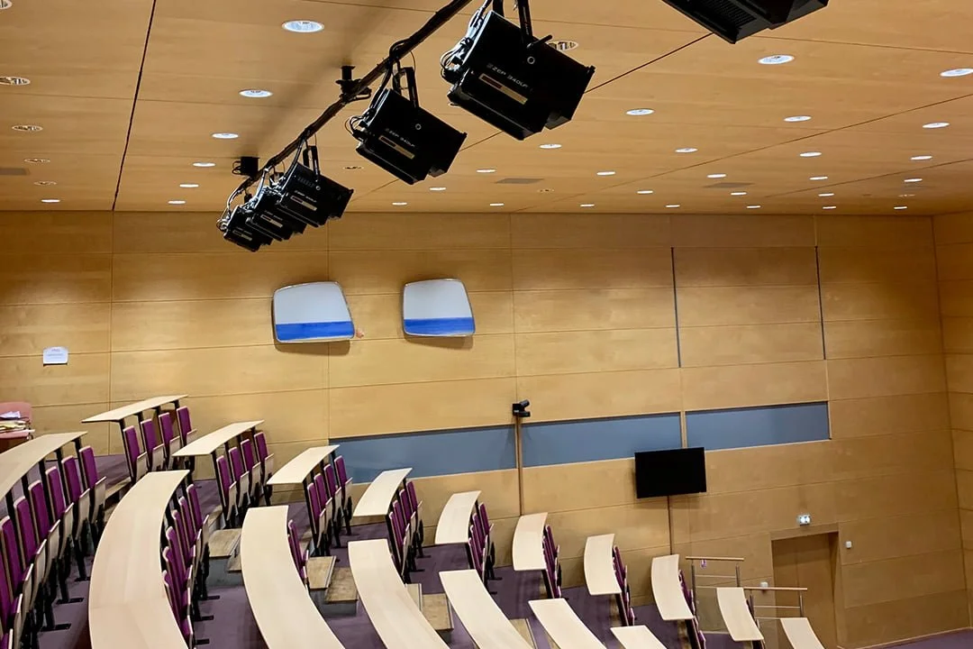 Salle de conférence vide avec sièges et éclairage.